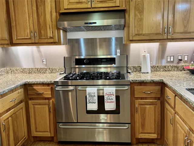 a kitchen with granite countertop stainless steel appliances and cabinets