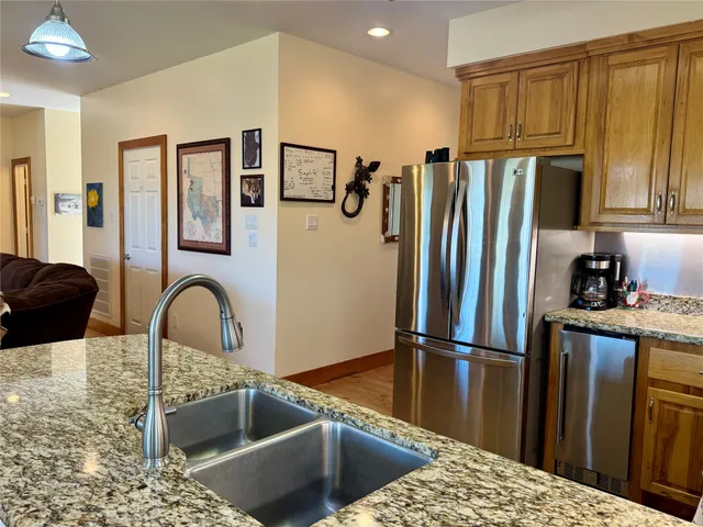 a kitchen with granite countertop a refrigerator and a sink