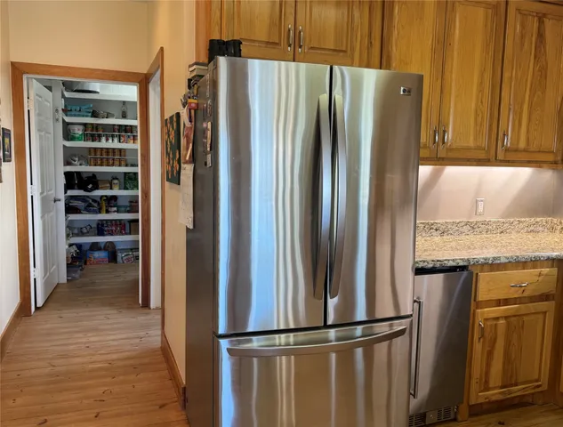 a kitchen with stainless steel appliances granite countertop a refrigerator and a sink