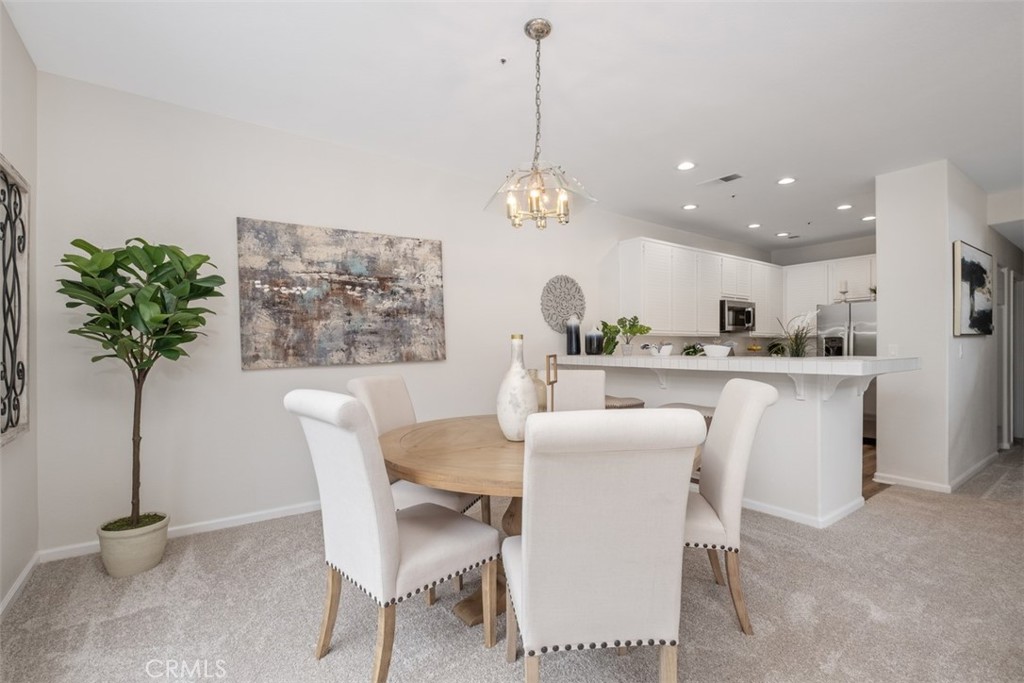 10 Finca San Clemente, CA 92672 - Photo 5 of 27 a dining room with furniture a potted plant and a chandelier