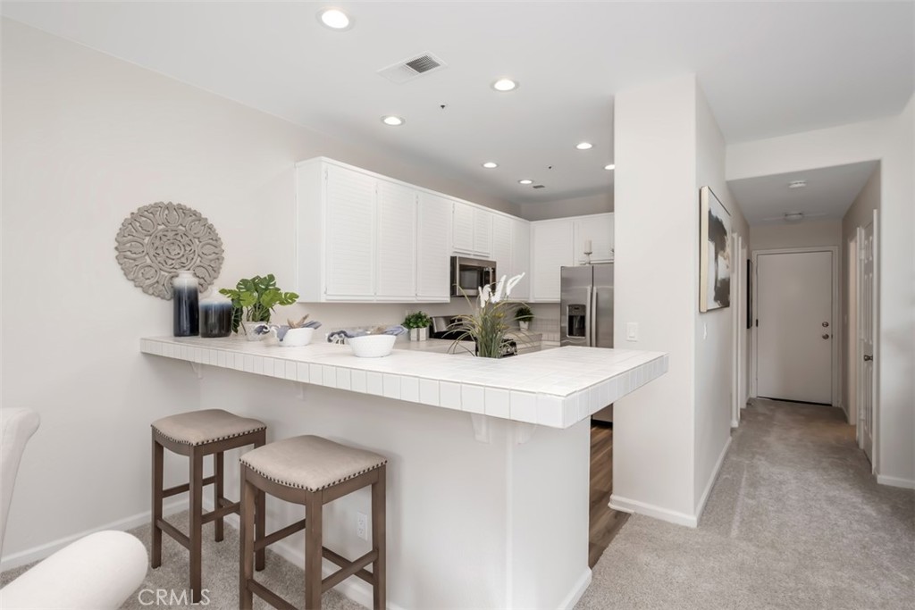 10 Finca San Clemente, CA 92672 - Photo 7 of 27 a kitchen with stainless steel appliances a sink a table and chairs in it