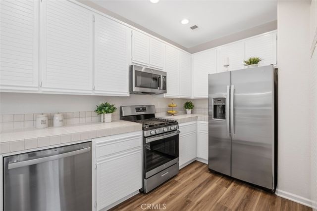 a kitchen with stainless steel appliances granite countertop a refrigerator sink and microwave