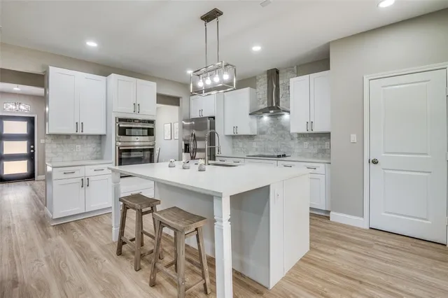 a kitchen with kitchen island granite countertop a sink a center island and cabinets