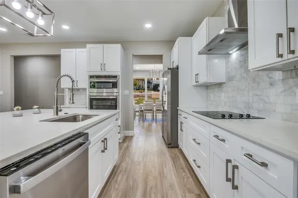 a large kitchen with stainless steel appliances granite countertop a lot of counter space a sink and a stove