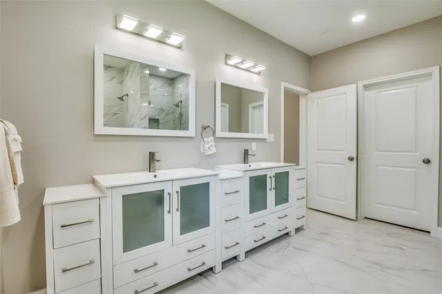 a spacious bathroom with a double vanity sink a mirror and a