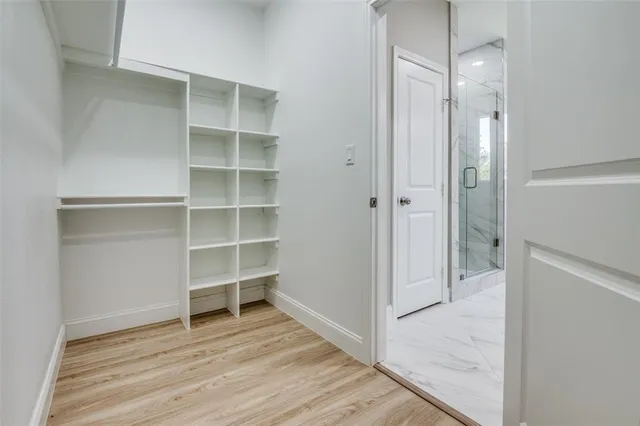 a view of an empty room with wooden floor and closet