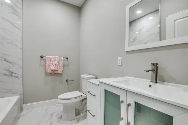 a bathroom with a toilet sink and mirror