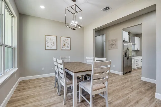 a view of a dining room with furniture a chandelier and wooden floor