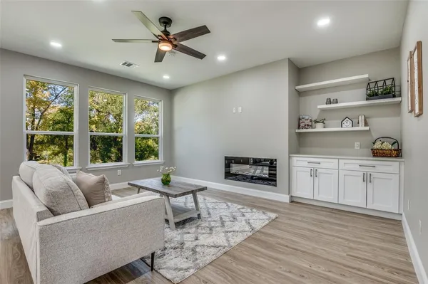 a living room with furniture and a large window with kitchen view