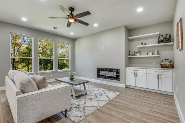 a living room with furniture and a large window with kitchen view