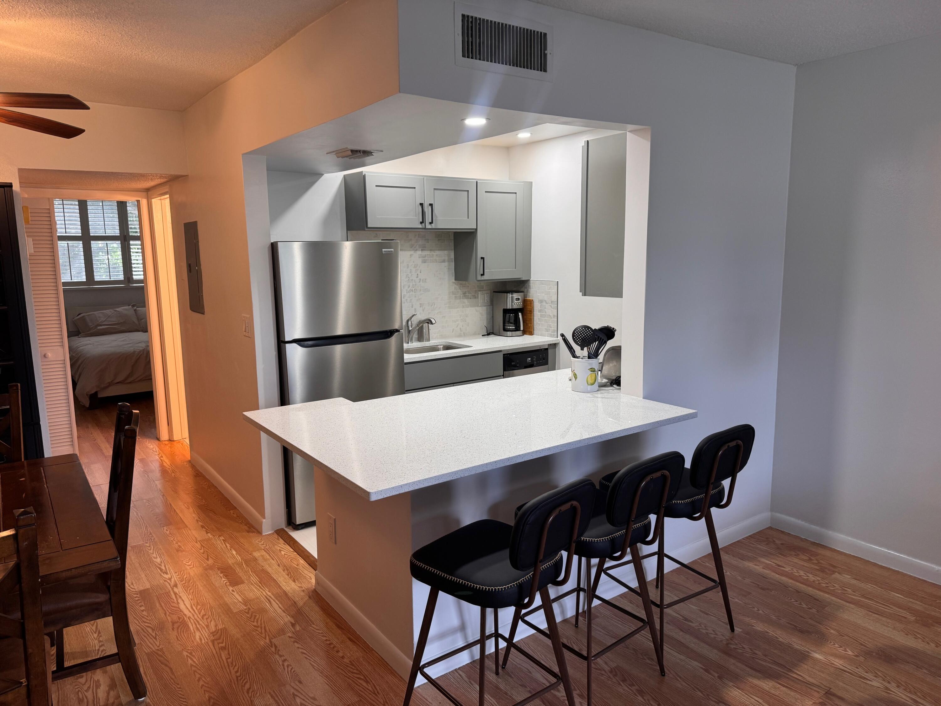 2565 South Ocean Boulevard, Unit 2060 Palm Beach, FL 33480 - Photo 11 of 17 a kitchen with a table chairs and a refrigerator