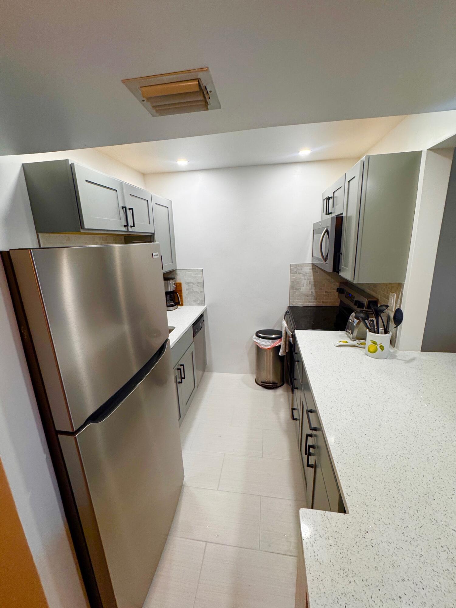 2565 South Ocean Boulevard, Unit 2060 Palm Beach, FL 33480 - Photo 12 of 17 a kitchen with stainless steel appliances a refrigerator and a sink