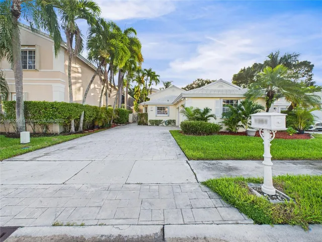 a front view of a house with a yard and potted plants