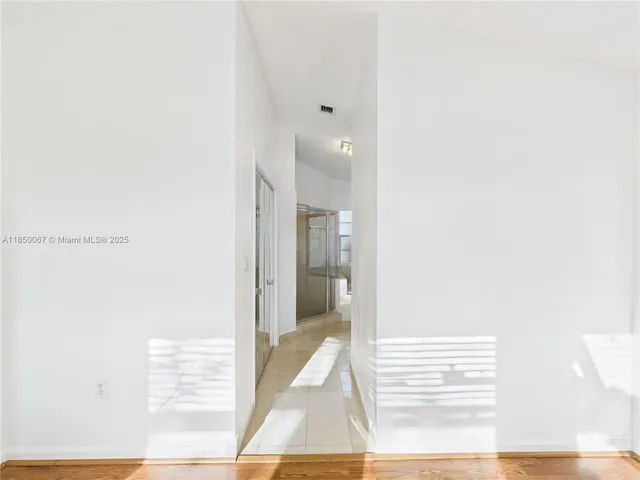 a view of a bedroom with wooden floor and windows