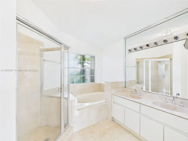 a bathroom with a bathtub shower sink and mirror