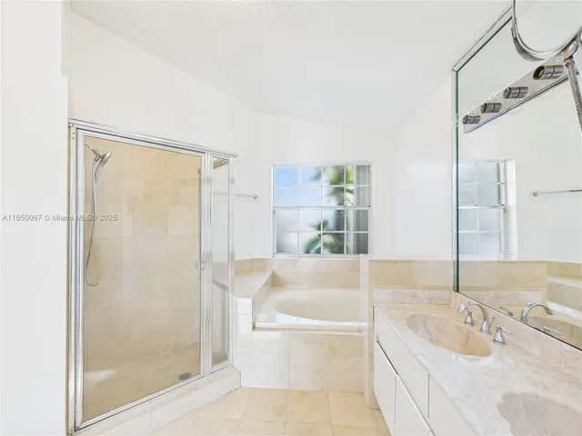 a bathroom with a tub shower and sink