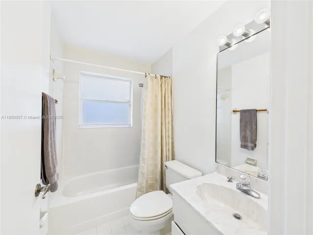 a bathroom with a bathtub shower sink vanity and toilet