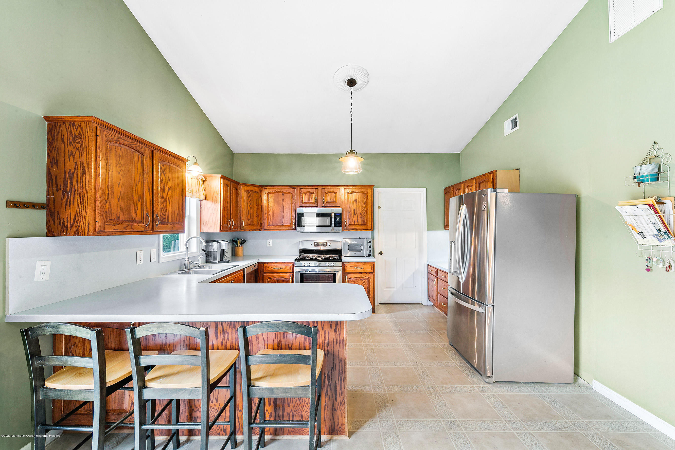 121 Wave Road Manahawkin, NJ 08050 - Photo 15 of 40 a kitchen with granite countertop a refrigerator a stove a sink dishwasher a dining table and chairs with wooden floor