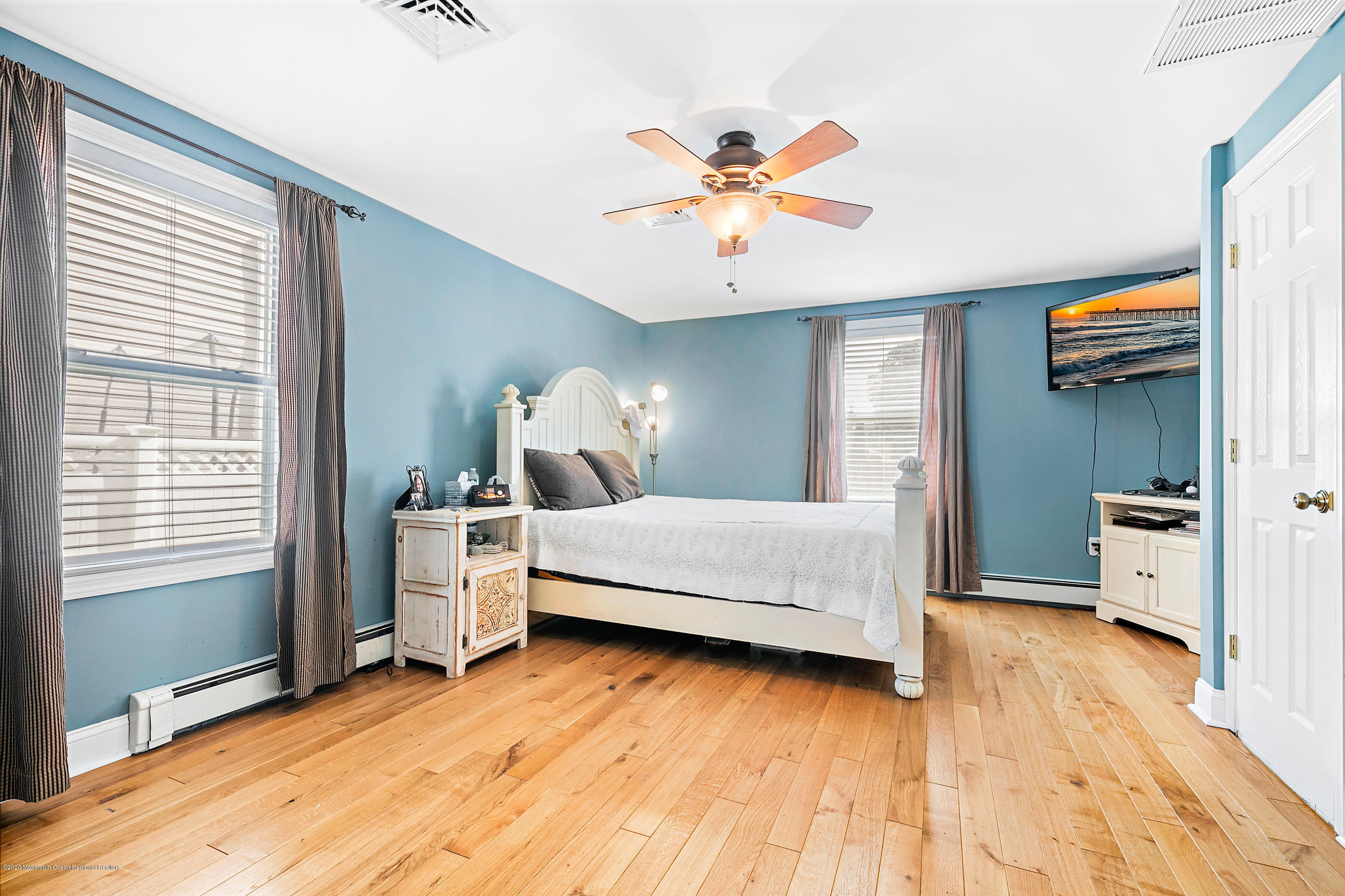 121 Wave Road Manahawkin, NJ 08050 - Photo 26 of 40 a bedroom with a bed and a chandelier