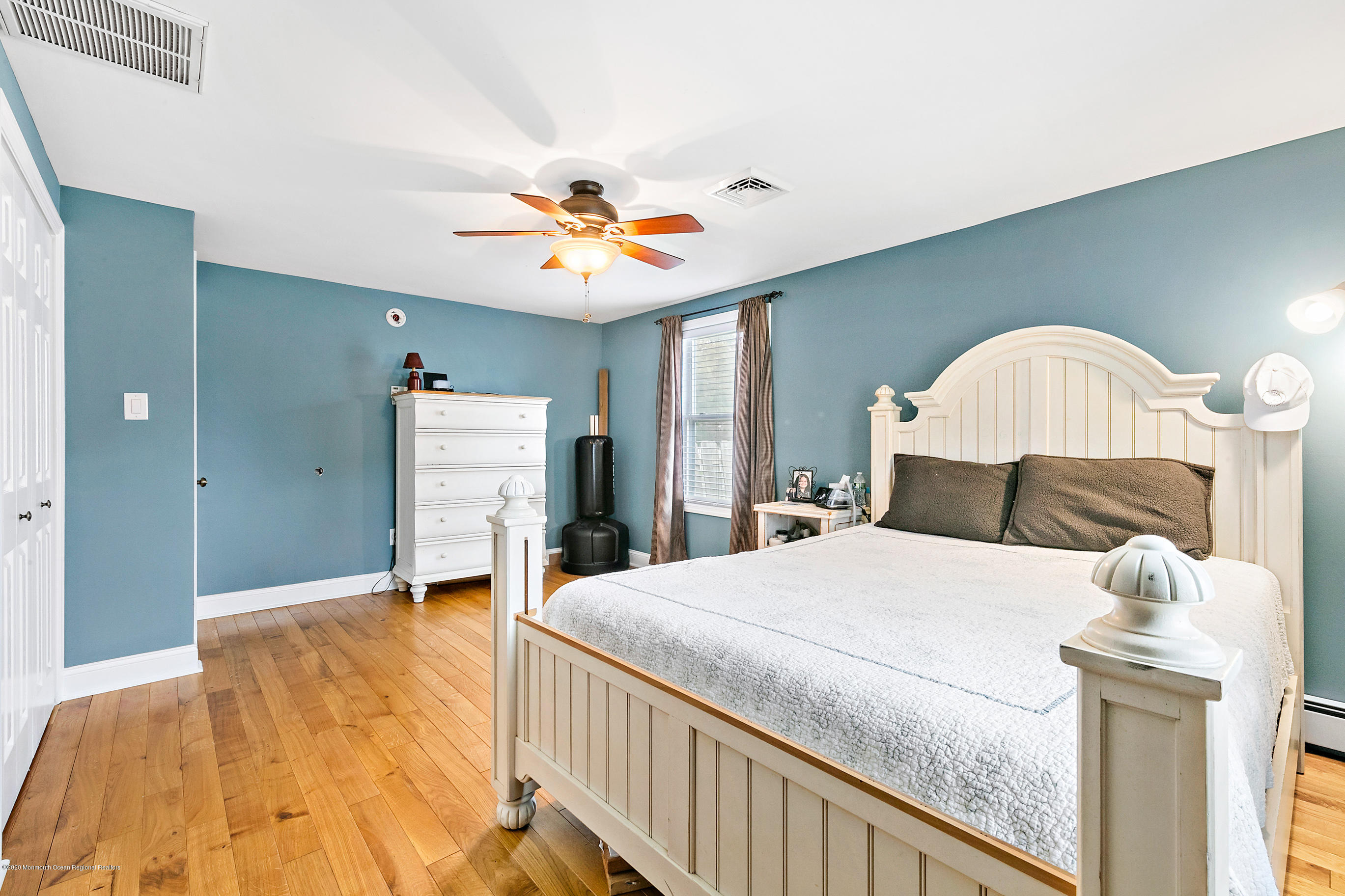 121 Wave Road Manahawkin, NJ 08050 - Photo 28 of 40 a bedroom with a bed and a chandelier