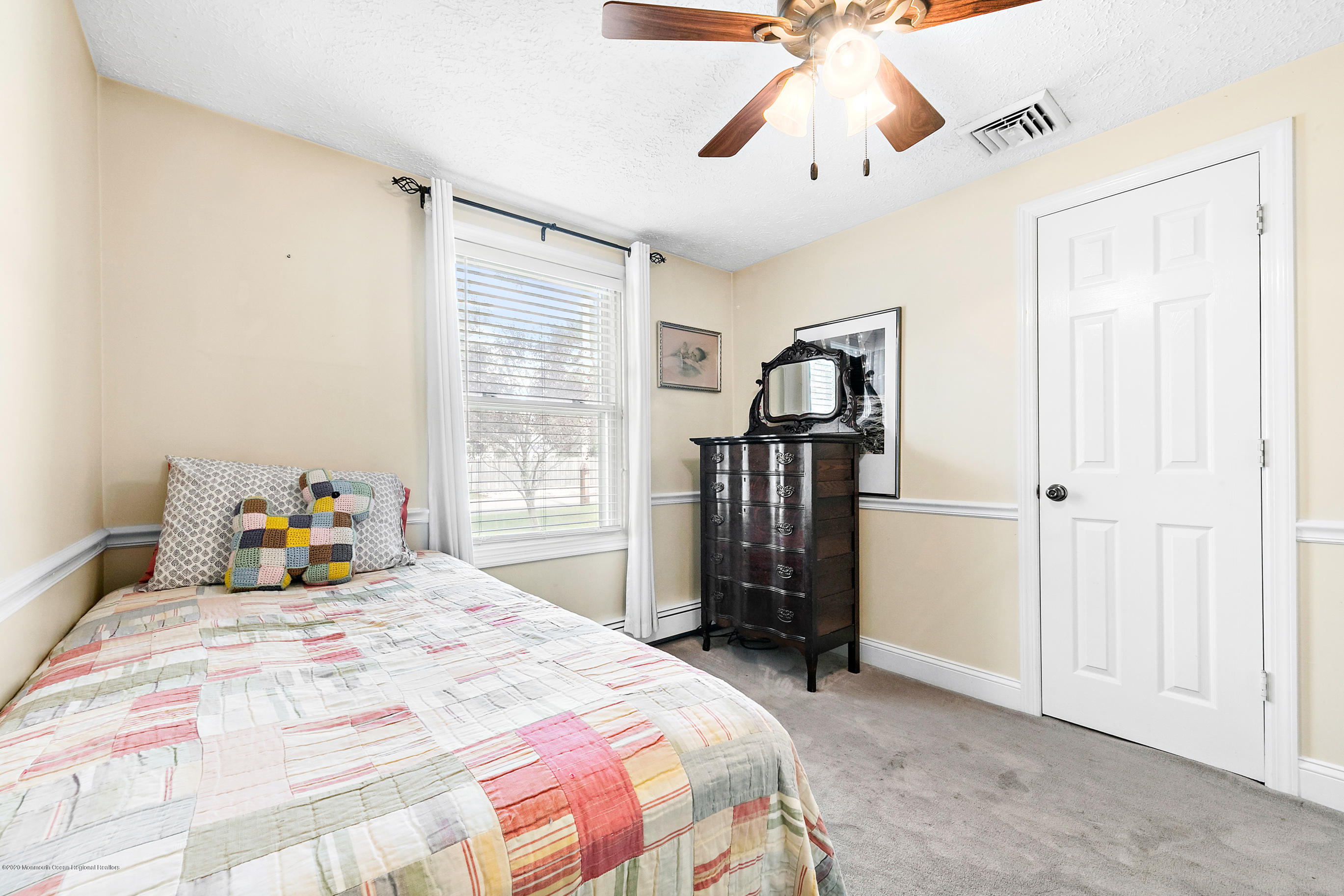 121 Wave Road Manahawkin, NJ 08050 - Photo 32 of 40 a bedroom with a bed and a chandelier