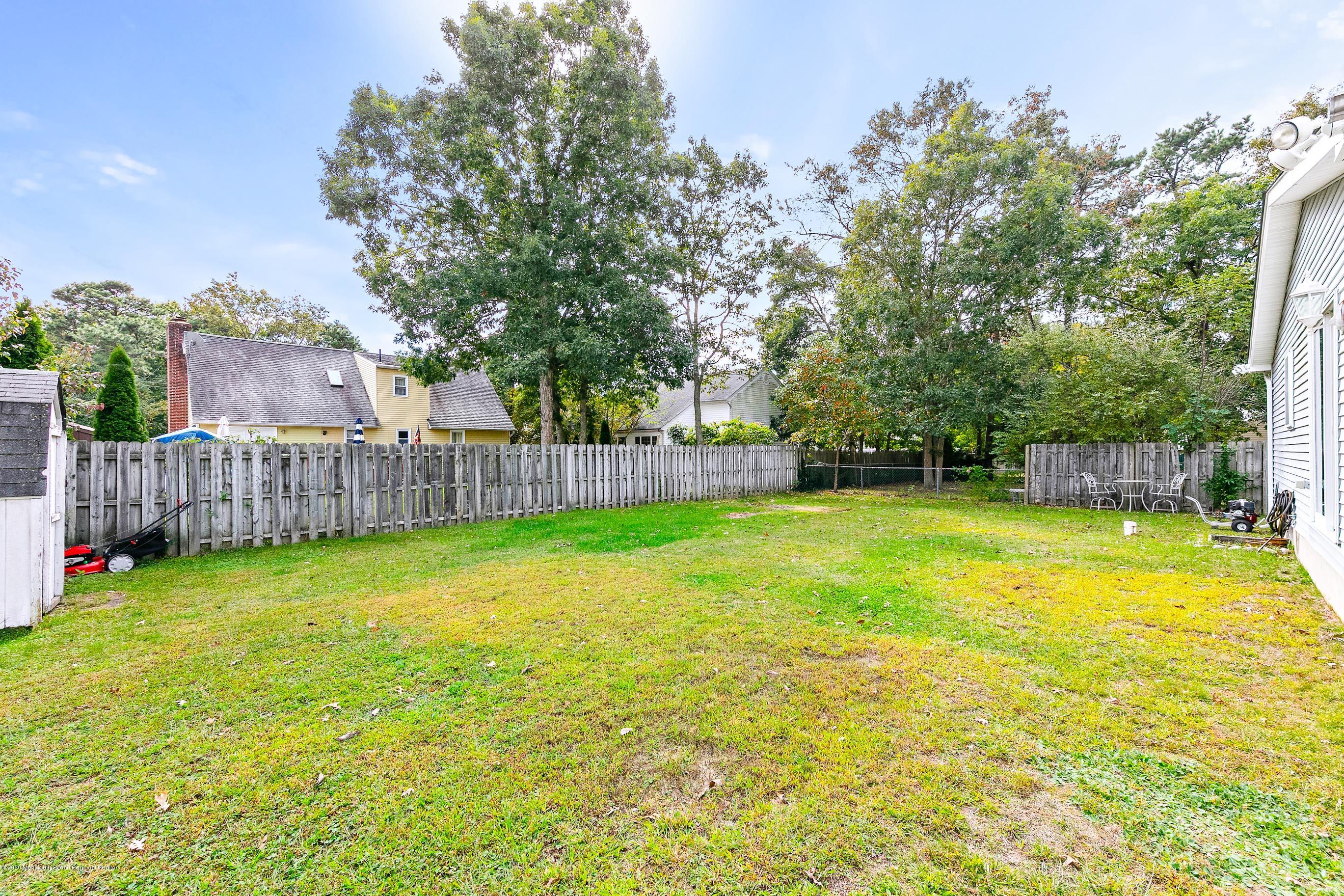121 Wave Road Manahawkin, NJ 08050 - Photo 40 of 40 a view of a yard with small cabin and wooden fence