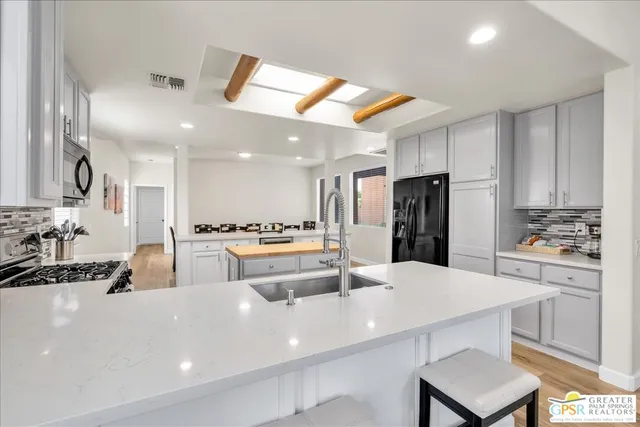 a large kitchen with a large counter top appliances and cabinets