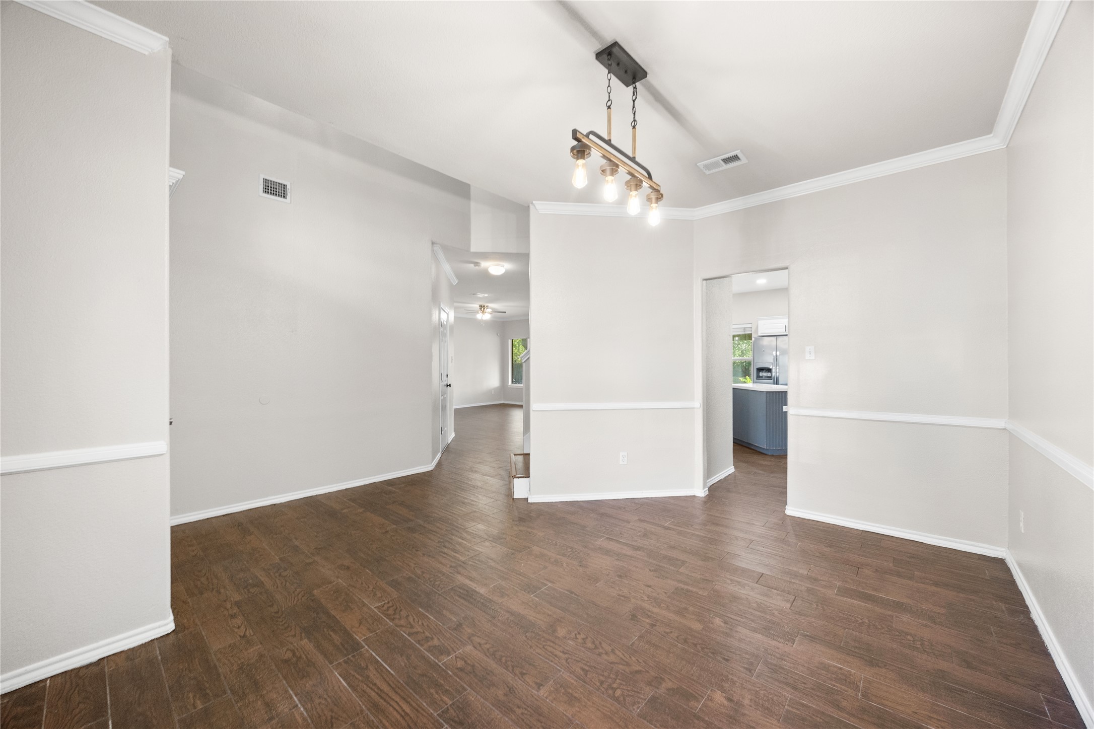 13217 Rochester Lane Austin, TX 78753 - Photo 15 of 30 Gleaming wood-look floors, crisp crown molding, and a rustic light fixture define this versatile space.