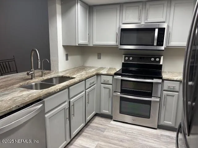 a kitchen with granite countertop a sink and steel appliances