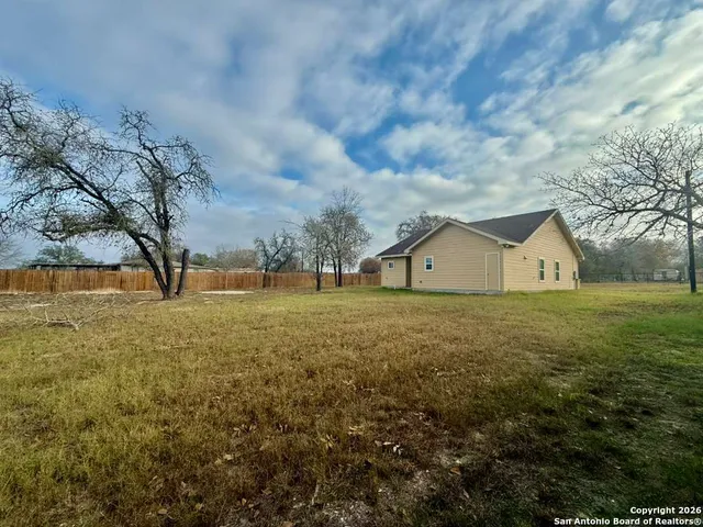 a front view of a house with a yard and lake view in back