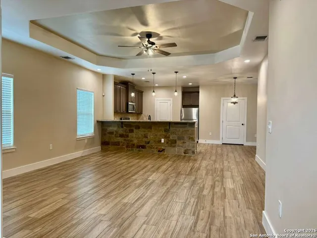 a large room with lots of counter space and wooden floor