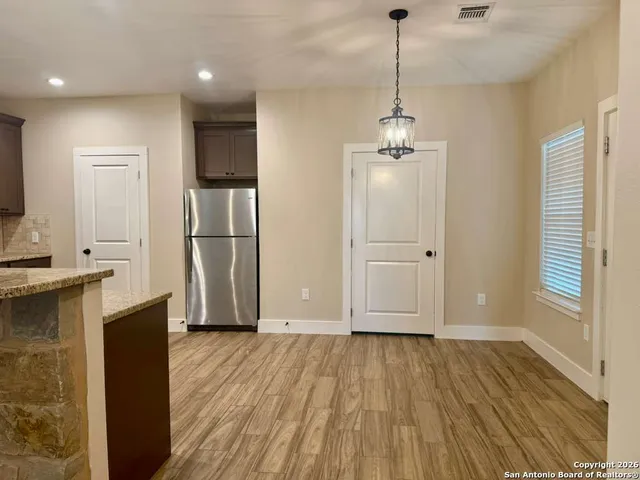 a kitchen with kitchen island granite countertop a sink and a stove top oven
