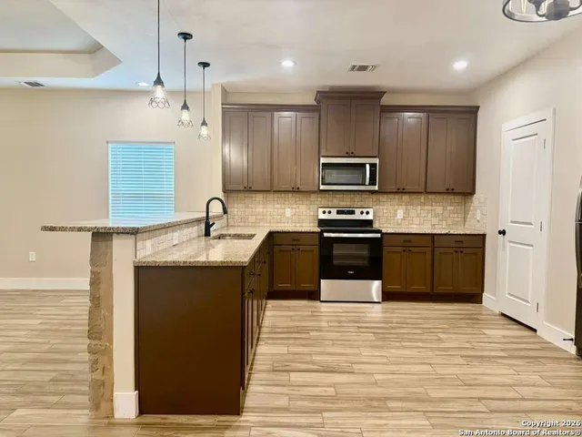 a kitchen with stainless steel appliances granite countertop a sink and microwave