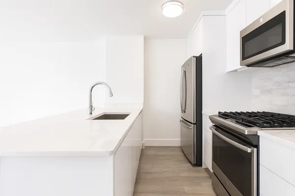 a kitchen with stainless steel appliances granite countertop a sink and a refrigerator
