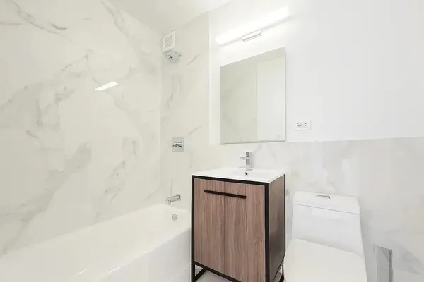 a bathroom with a bathtub sink vanity and toilet