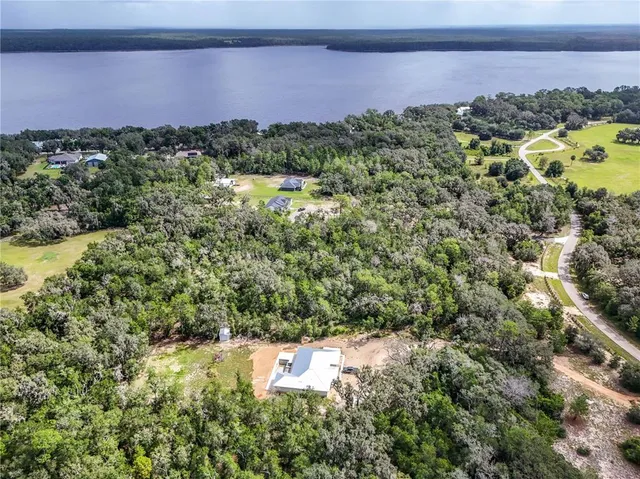 an aerial view of mountain with residential house and lake view