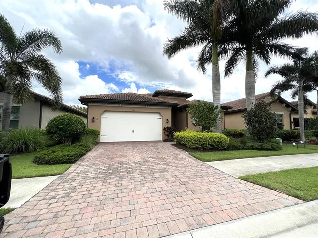 a front view of a house with a garden and a garage
