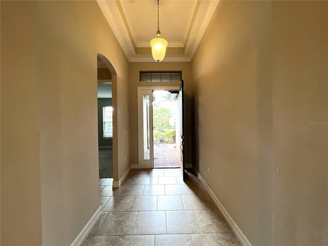 a view of a hallway with wooden floor and a bathroom