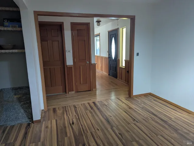 a view of a hallway with wooden floor