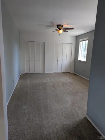 a view of a livingroom with a ceiling fan and window