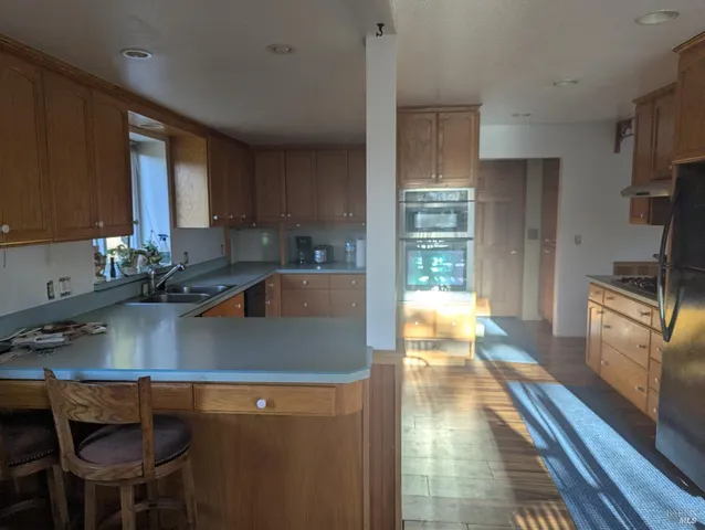 a kitchen with a sink a counter top space cabinets and stainless steel appliances