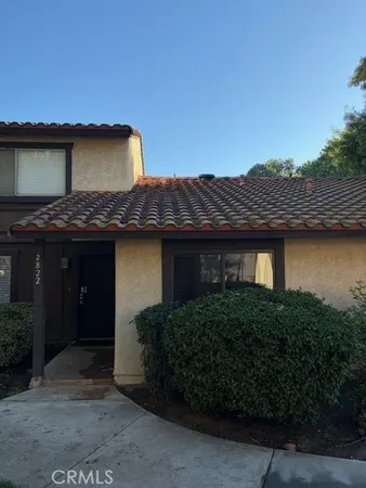 a view of a house with wooden fence and a yard