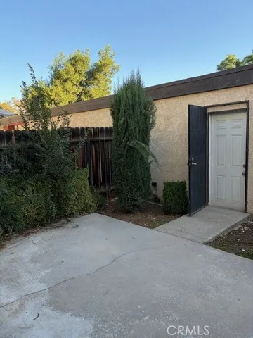 a view of a house with a yard and potted plants