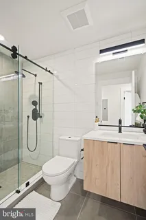 a bathroom with a granite countertop sink toilet and shower