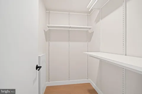 a view of walk in closet with empty racks