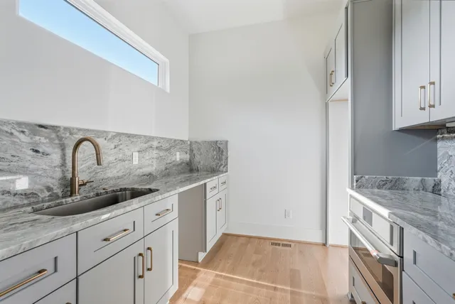 a kitchen with granite countertop white cabinets and a sink