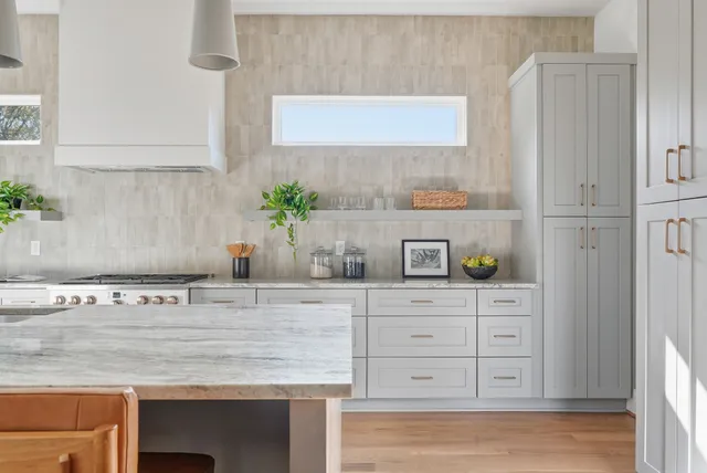 a kitchen with granite countertop a sink and a white cabinets