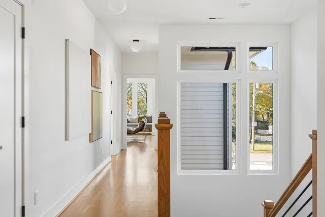 a view of a hallway with windows and chandelier