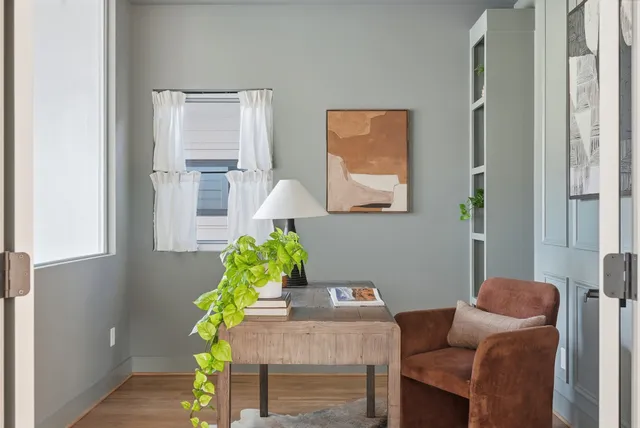 a living room with furniture flowerpot and wooden floor
