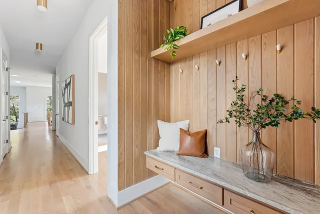 a view of a hallway with wooden floor and a potted plant